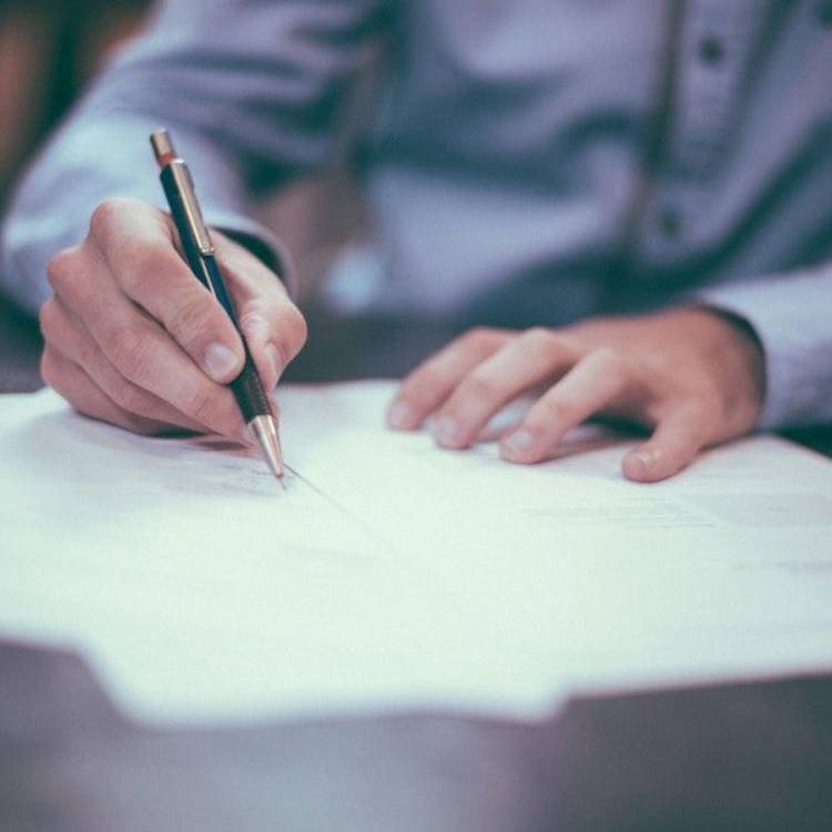 Man writing on sheets of paper